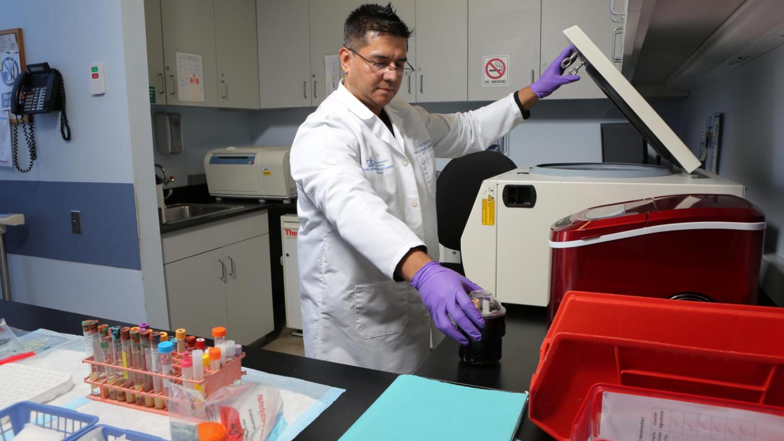 Man in white coat with blood samples.
